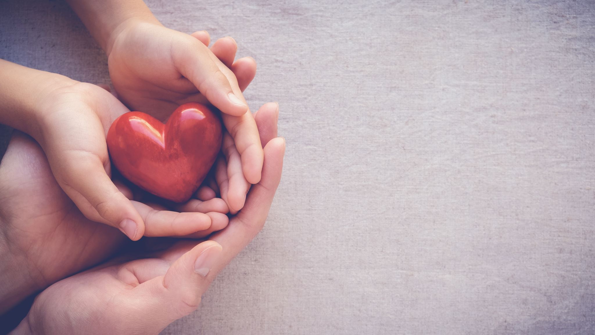 Large-and-small-hands-holding-red-heart